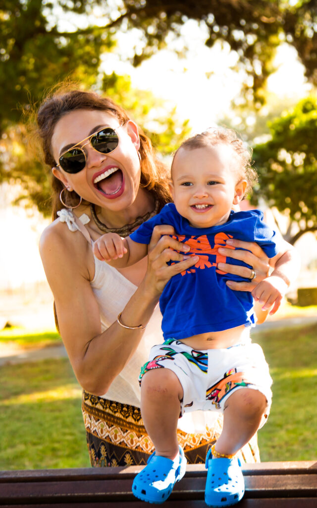 Mother smiling with her baby during a relaxed family session in a garden