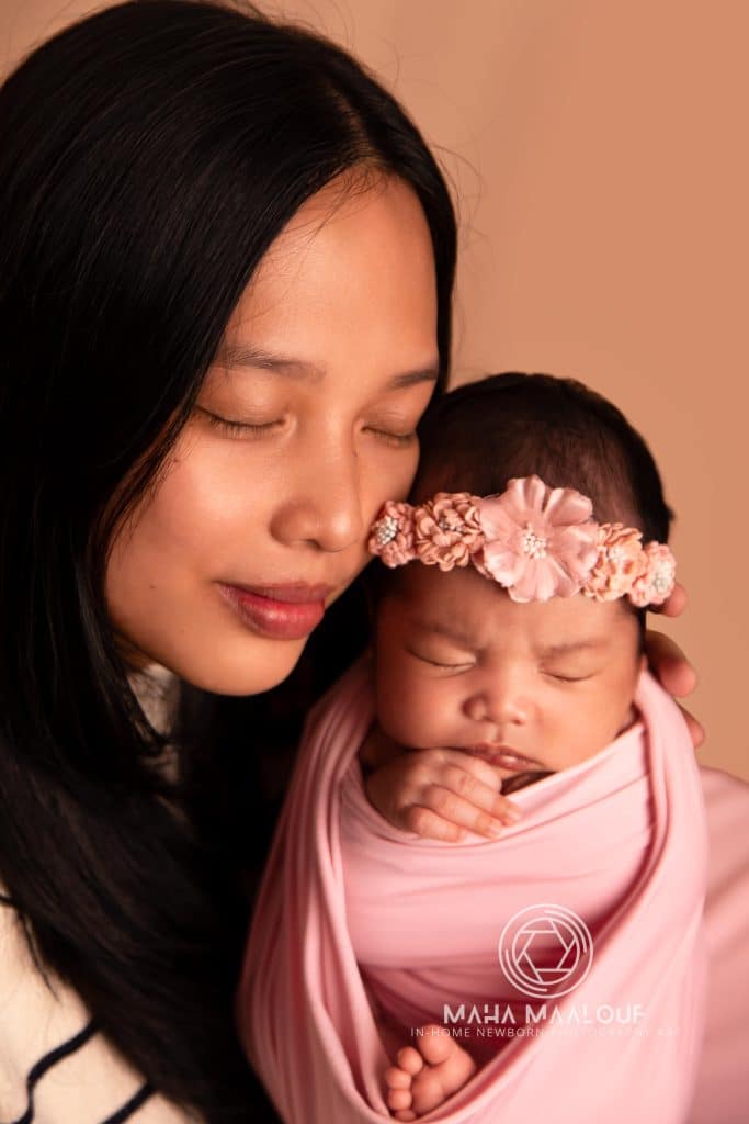 Mother cuddling newborn baby during in-home newborn photography