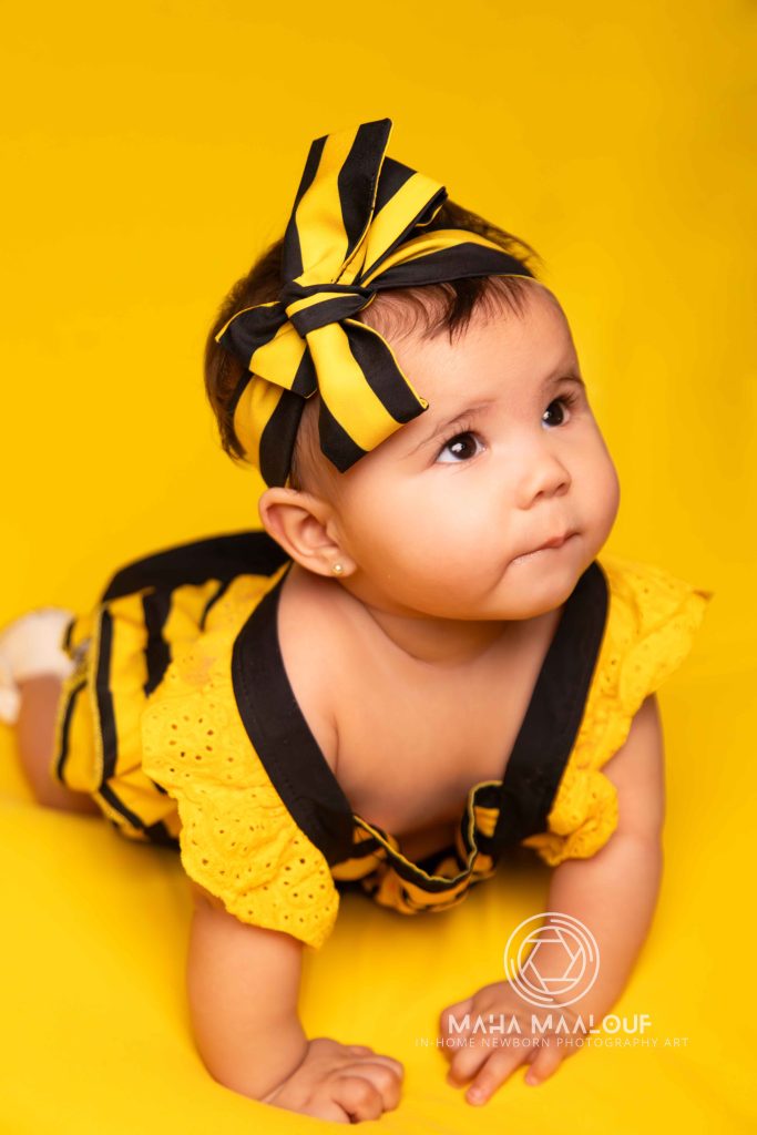 Baby portrait on a yellow background during a monthly milestone session
