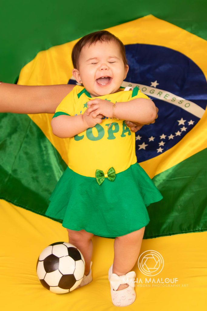 Baby in green and yellow outfit during a monthly milestone photoshoot