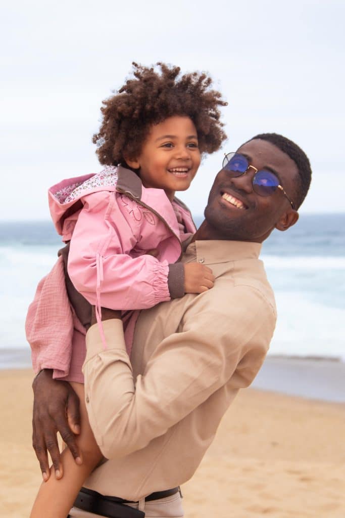 Pai com filha durante sessão de fotografia de família na praia em Lisboa