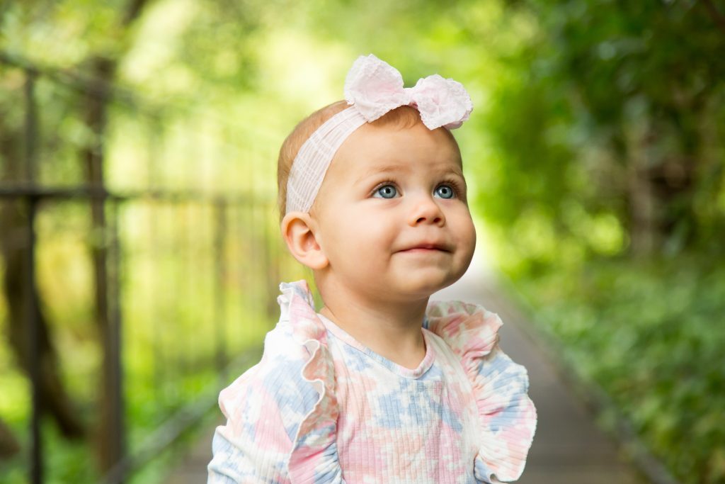 Retrato de bebé durante sessão de fotografia de família num jardim em Lisboa