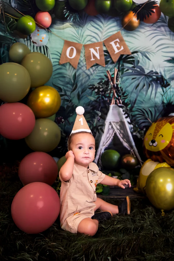 Bebé em cenário safari com decoração de primeiro aniversário